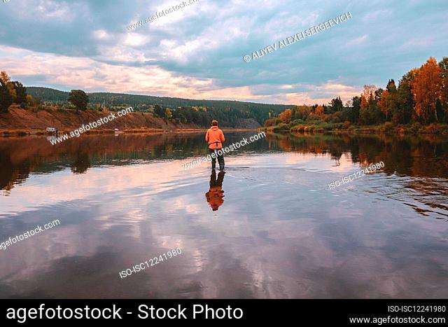 Angler fishing in middle of lake in autumn, Russia