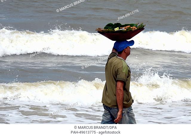 A beach seller walks on the beach in Porto Seguro, Brazil, 23 June 2014. The FIFA World Cup will take place in Brazil from 12 June to 13 July 2014