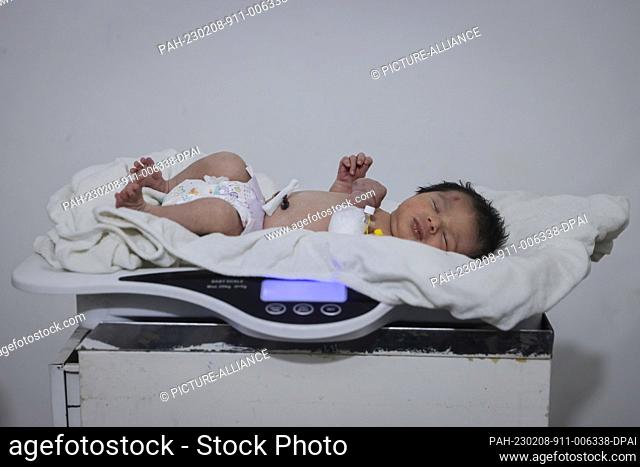 GRAPHICS - 08 February 2023, Syria, Afrin: A newborn girl lies on a scale as part of her medical check-up at a children's hospital in the Syrian town of Afrin