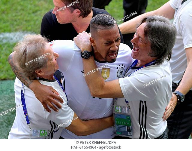 Jerome Boateng (C) of Germany celebrates with physiotherapist Klaus Eder (L), team doctor Hans-Wilhelm Mueller-Wohlfahrt (R) and assistant coach Thomas...