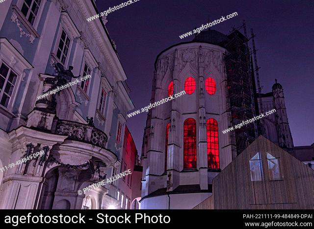 11 November 2022, Bavaria, Passau: Red light shines from windows at St. Stephen's Cathedral. In solidarity with persecuted Christians
