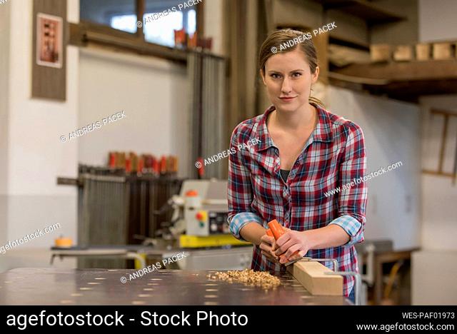 Young craftswoman working in woodshop