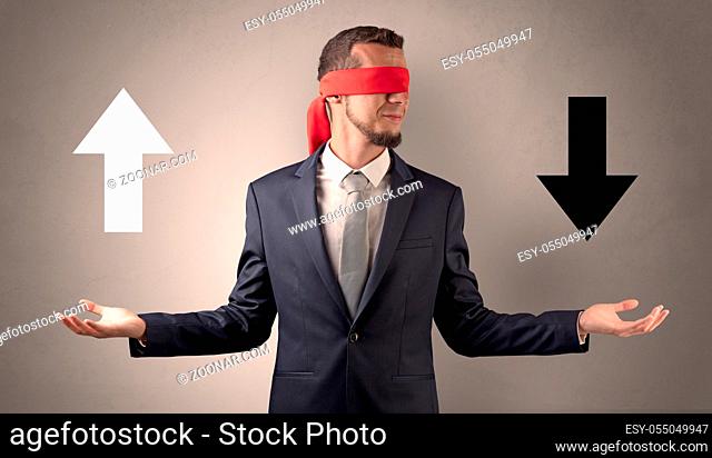 Covered eye businessman choosing between two directions