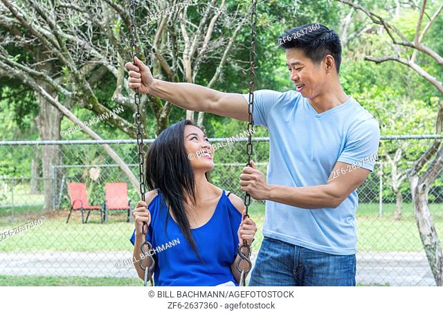 Vietnamese-American couple dating at playground with swings and having fun MR-6 MR-8 Model released