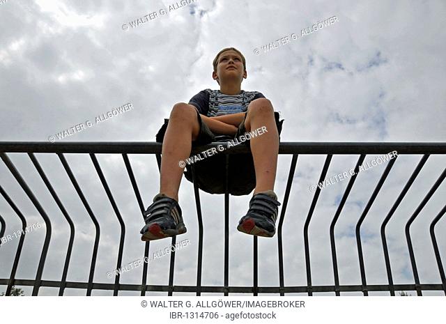 Lonely nine-year-old boy on a metal goal, mini football area in Cologne, North Rhine-Westphalia, Germany, Europe