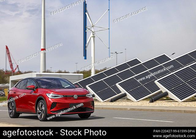26 April 2022, Saxony, Zwickau: An ID.5 GTX drives around Volkswagen's factory premises in Zwickau in front of solar panels