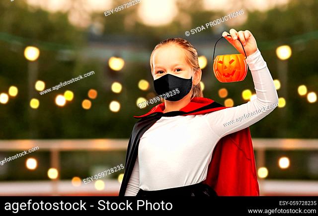 girl in mask and costume of dracula on halloween