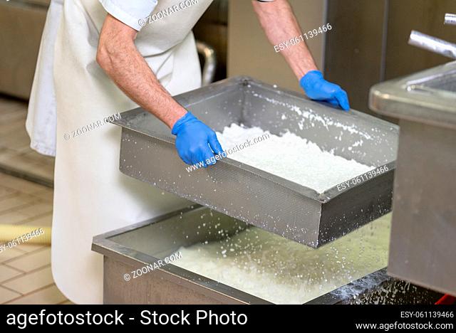 Food industry. Worker checking the conditions of fermentation of the cheese in a stainless steel tank