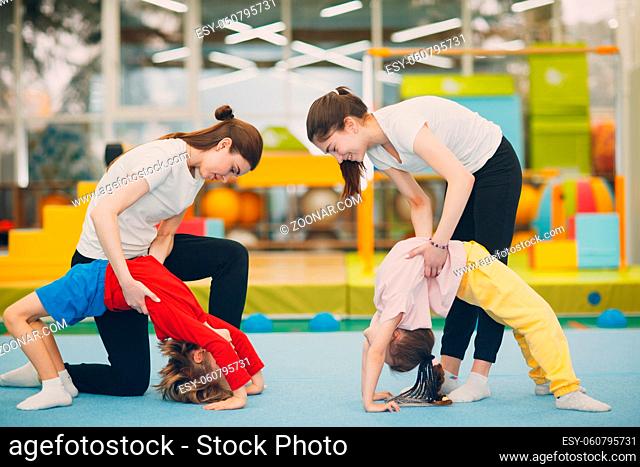 Kids doing exercise bridge in gym at kindergarten or elementary school. Children sport and fitness concept