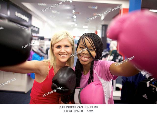 Two young women wearing boxing gloves and looking at the camera, Pietermaritzburg, KwaZulu-Natal, South Africa
