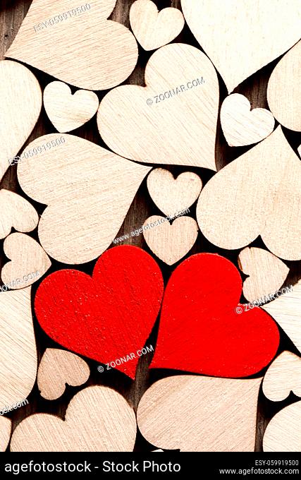 Many wooden colorless hearts background, two red special ones true love concept