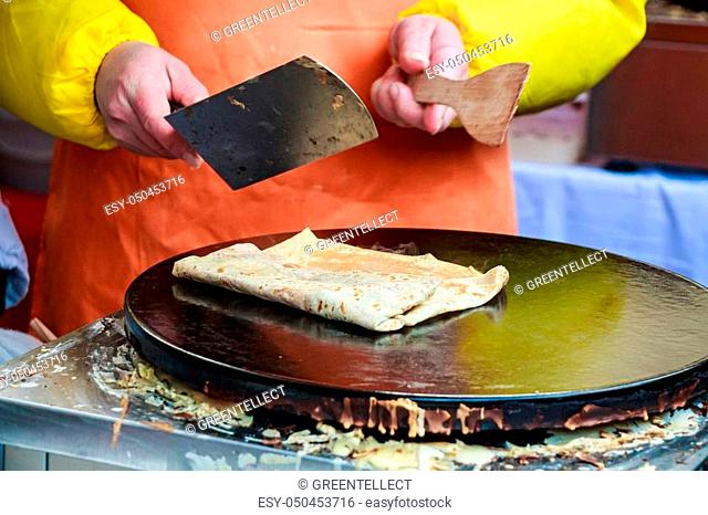 Close up of making crepe with jam outdoors on skillet