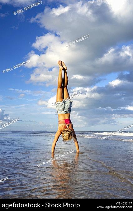 Woman doing yoga handstand on beach - Pompano Beach, Florida, USA