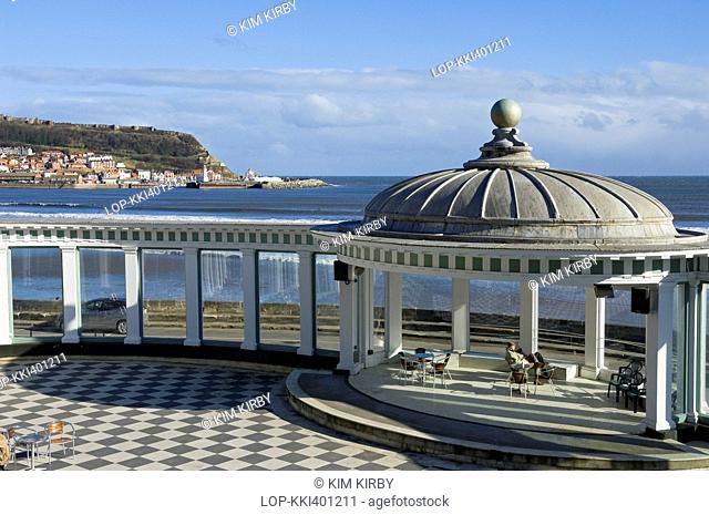 England, North Yorkshire, Scarborough. A couple relaxing in the bandstand at Scarborough Spa Complex in South Bay
