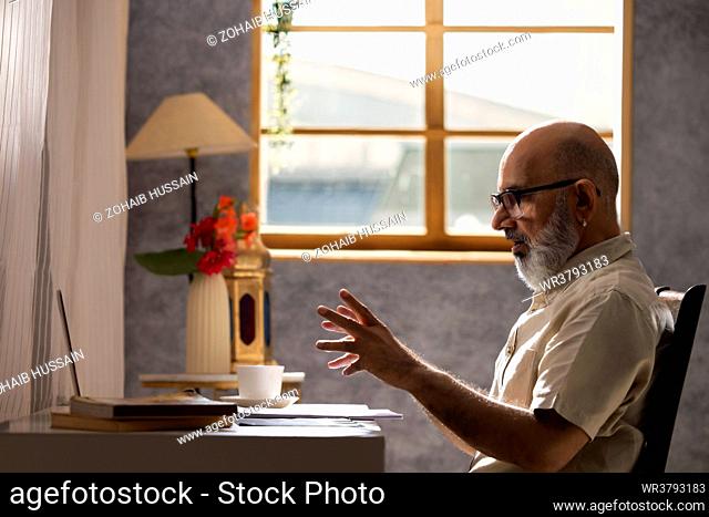 Portrait of senior man having video call through laptop