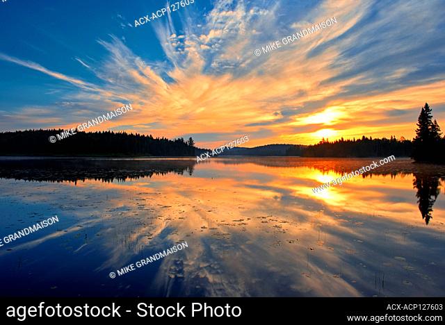 Reflection of clouds in Lac du Fou at sunrise La Mauricie National Park Quebec Canada