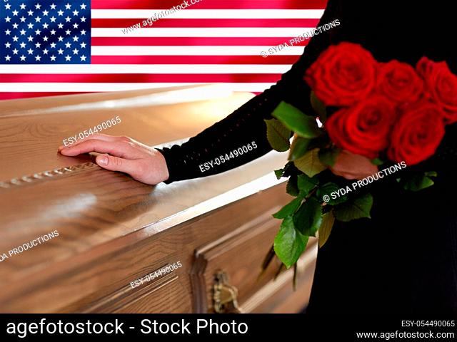 woman with red roses and coffin over american flag