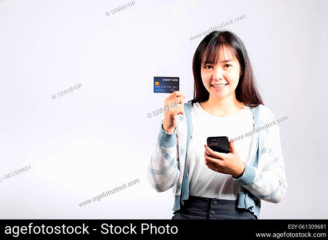 Woman excited smiling hold mobile phone and plastic debit credit bank card for payment studio shot isolated white background