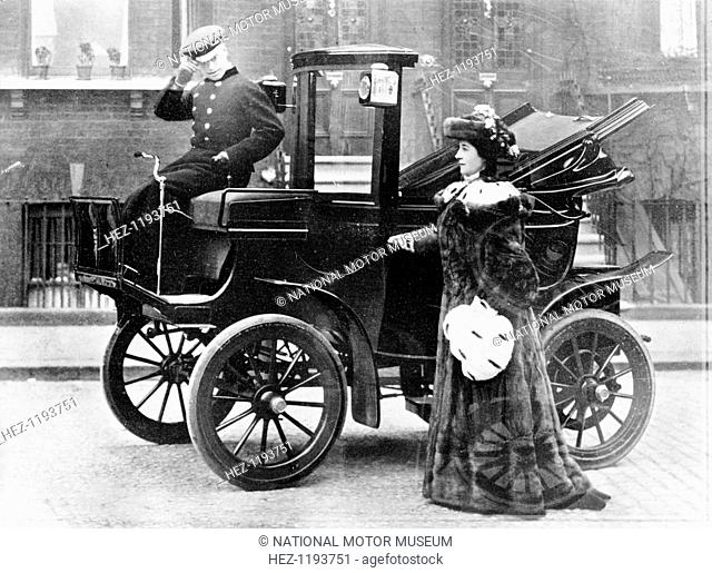 Lillie Langtry modelling a sable motoring coat. Standing next to an electric City and Suburban car. The driver tips his hat to the photographer