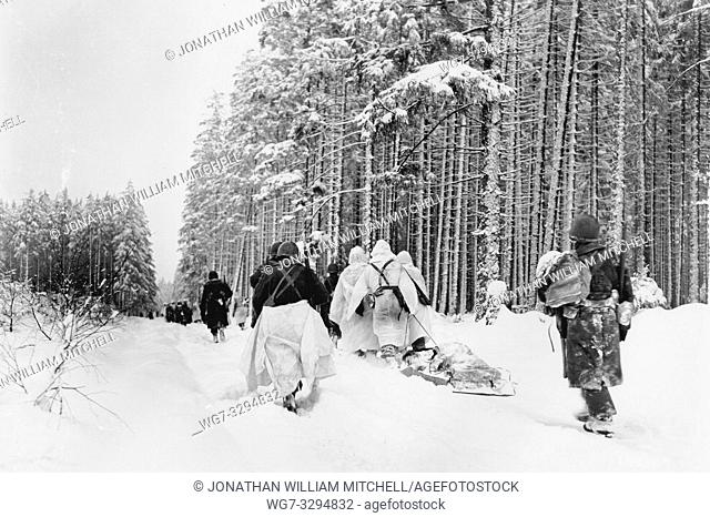 BELGIUM Herresbach -- 28 Jan 1945 -- American troops drag a heavily loaded ammunition sled through the snow, as they move for an attack on Herresbach, Belgium