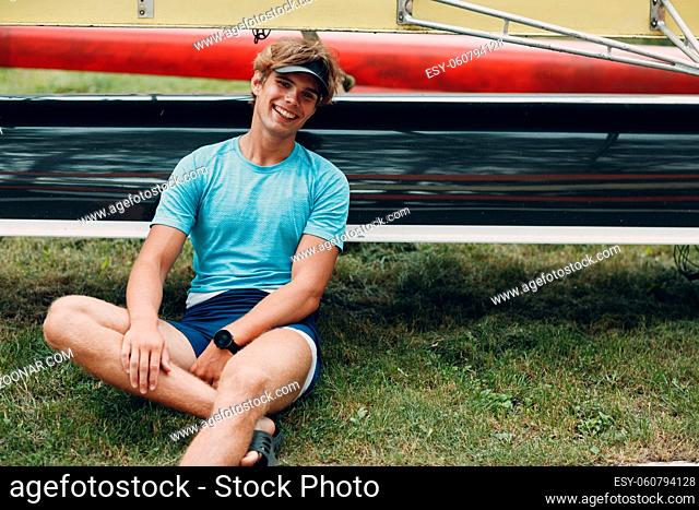Sportsman single scull man rower portrait sitting relaxing after training competition boat regatta. Olympic games sport