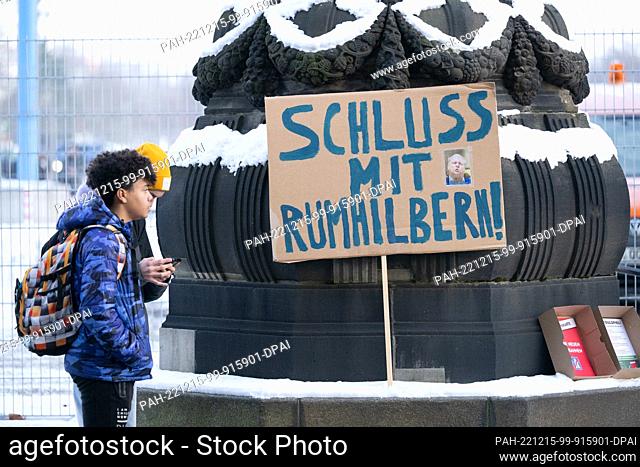 15 December 2022, Saxony, Dresden: Participants of a climate strike of DresdenZero and Fridays for Future stand next to a sign with the inscription ""Schluss...