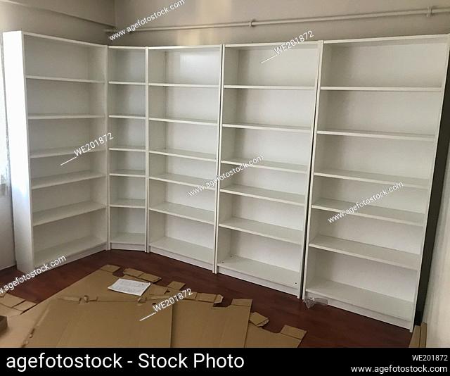 Empty white bookshelf and after mounting the bookcase in the home after moving