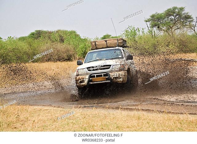 off-road vehicle on muddy dirt road, Africa