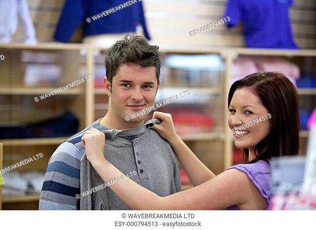 cute woman choosing clothes for her boyfriend in a shop