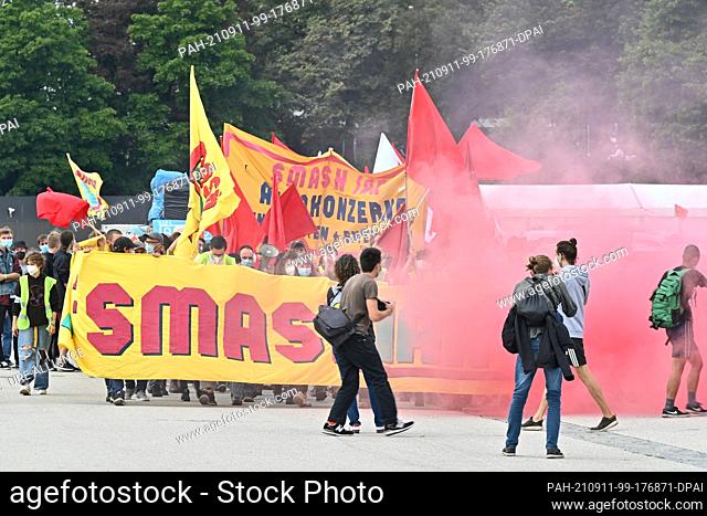 13 March 2020, Bavaria, Munich: A group with a banner reading ""Smash IAA"" walks across the Theresienwiese grounds. A demonstration and a bicycle rally against...
