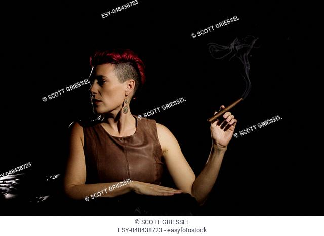 Modern woman with fuchsia hair holding a cigar