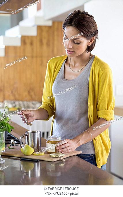 Woman preparing herbal tea in the kitchen