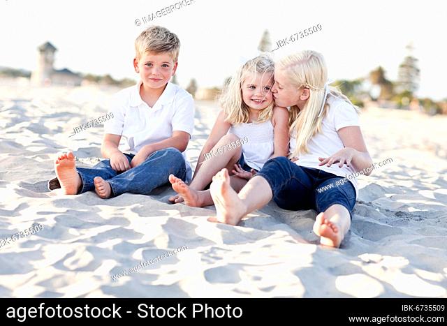 Adorable sisters and brother having A lot fun at the beach
