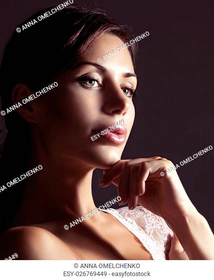 Closeup portrait of a nice female with gentle look over dark background, pretty woman wearing stylish morning lace lingerie