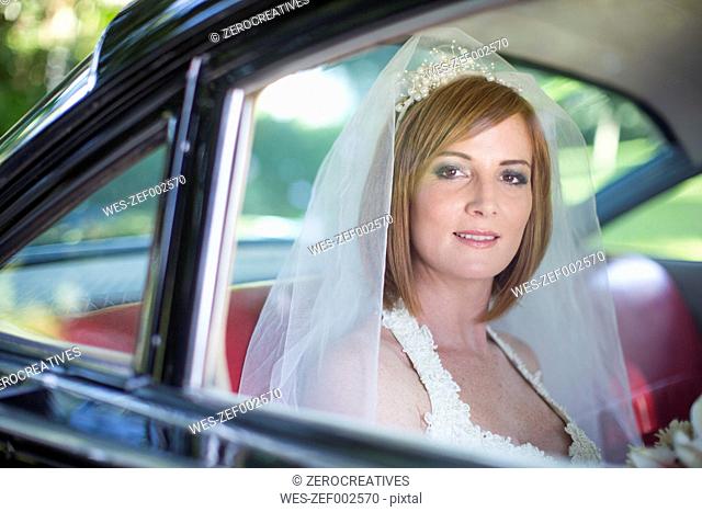 Bride sitting in car before wedding