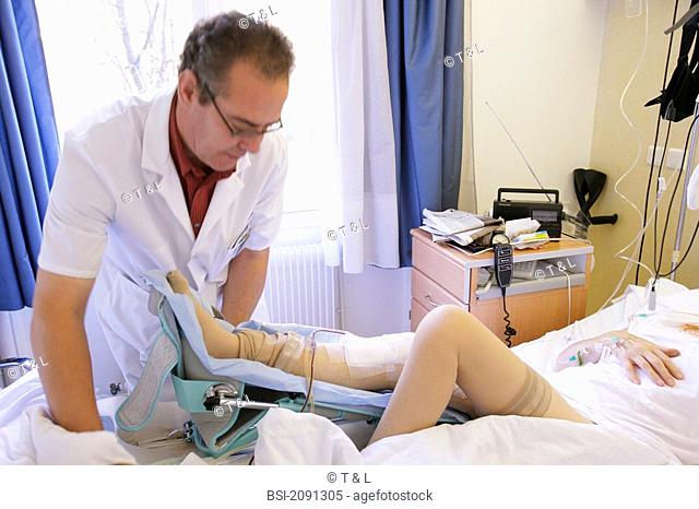 ELDERLY P. IN PHYSICAL THERAPY<BR>Photo essay from clinic.<BR>Physical therapist. Orthopedic clinic. Rehabilitation consisting in folding and unfolding the leg