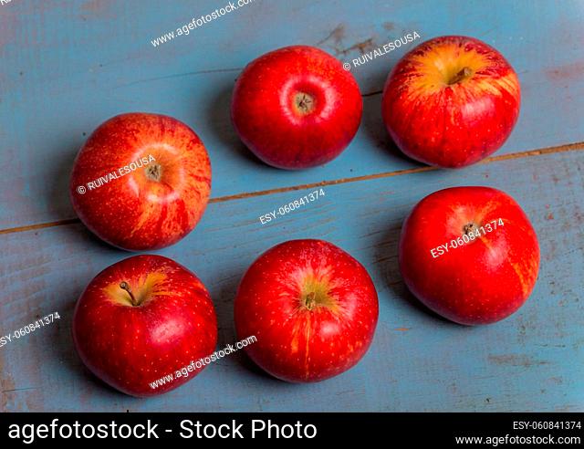 red apples on a old blue wooden table, studio picture