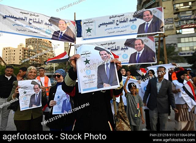 18 December 2023, Egypt, Cairo: People hold posters of Egyptian President Abdel-Fattah el-Sisi to celebrate his re-election win