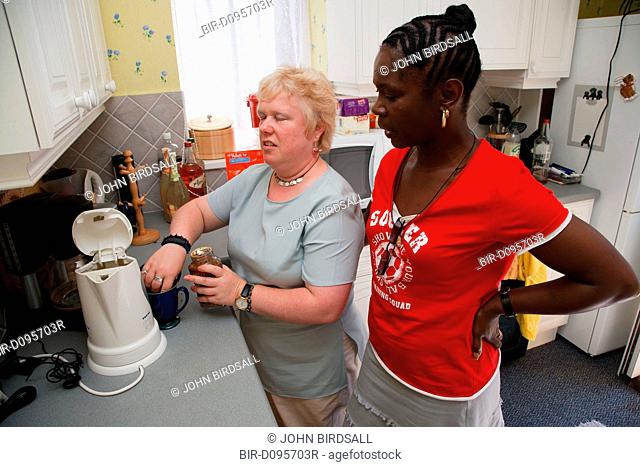 Woman with visual impairment with friend in kitchen