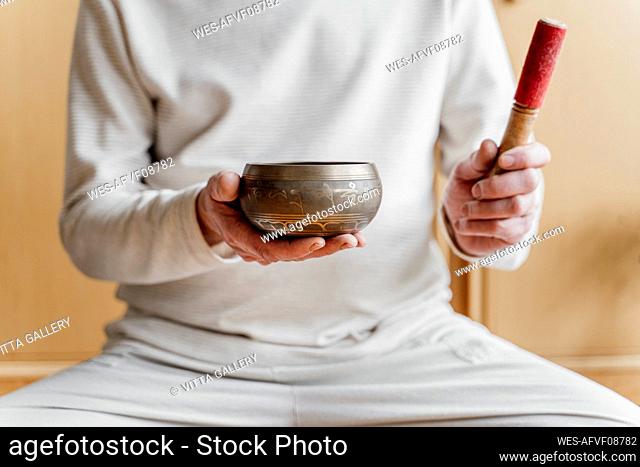 Man holding Tibetan Singing Bowl at home