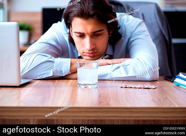 The sick male employee suffering in the office