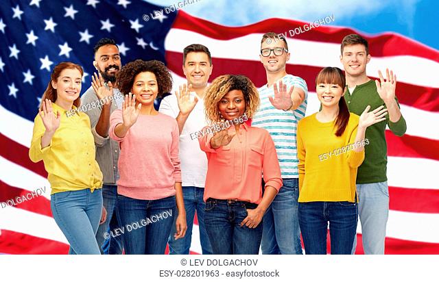 diversity, race, ethnicity and people concept - international group of happy smiling men and women waving hand over american flag background