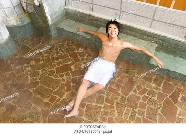 Man relaxing in hot tub, high angle view, Japan
