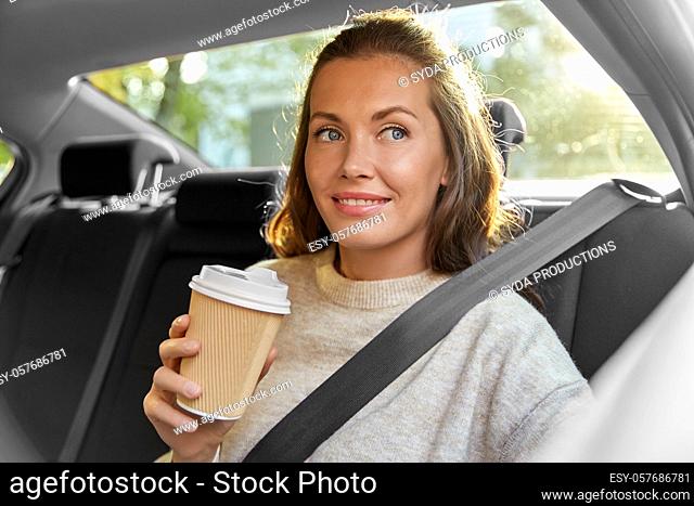 smiling woman or passenger drinking coffee in car