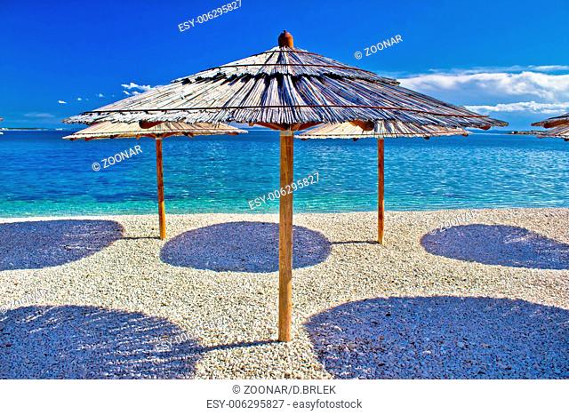 Pebble beach and turquoise sea umbrella