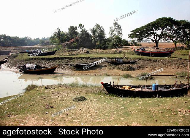 Boats of fishermen stranded in the mud at low tide on the coast of Bay of Bengal, India