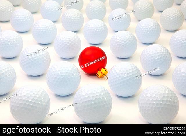 Pattern with white golf balls and red Christmas decoration on the table