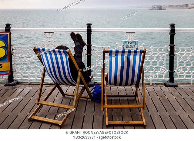 People Sitting On Deckchairs, Brighton Pier, Brighton, Sussex, UK