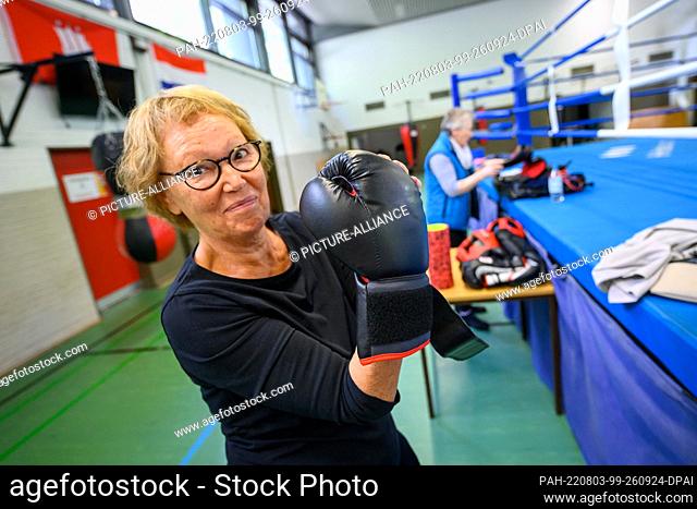 27 July 2022, Hamburg: Course participant Karin Schmitt puts on her boxing gloves. Kisikyol, a professional boxer and social pedagogue from Hamburg