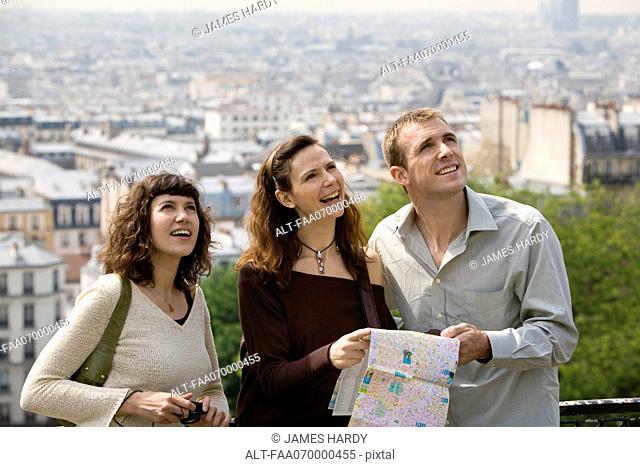 Tourists standing with map, looking up, Paris, France